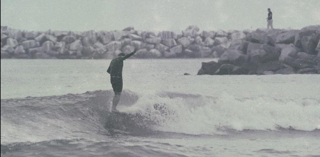 Surfer nose riding his single fin longboard.